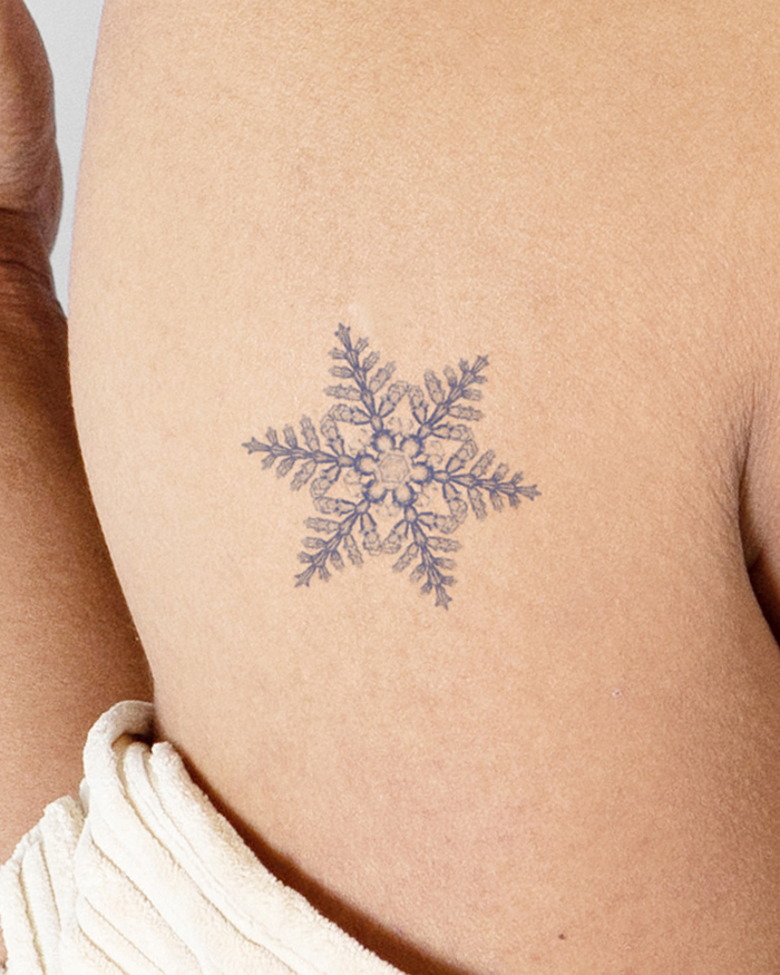 Little Tattoos — Three blue snowflake tattoos on the back of the...